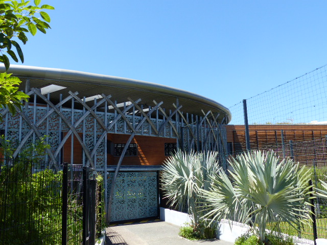 Façade d'un bâtiment livré outre-mer : résille métallique ajourée et bardage bois