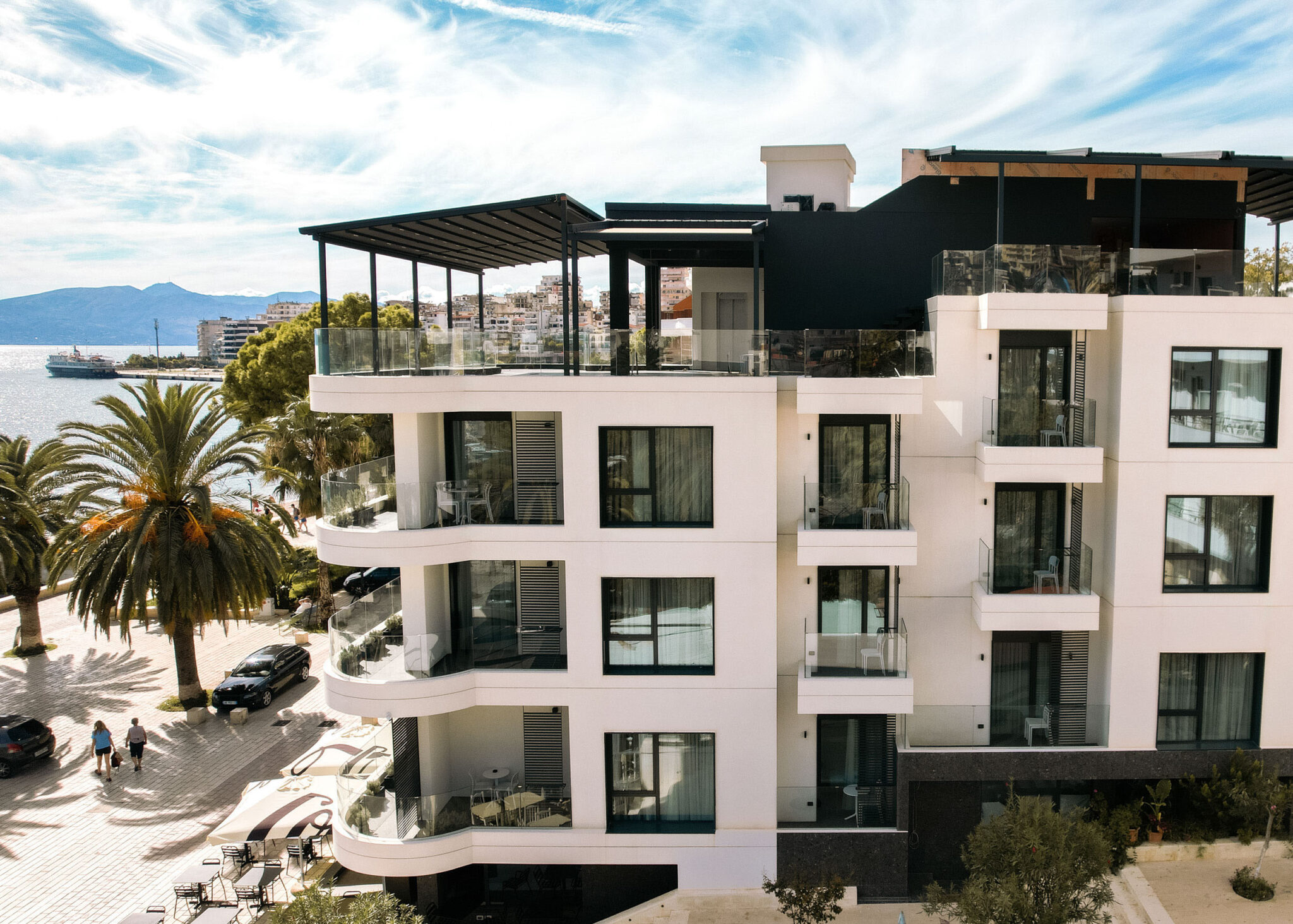 Immeuble résidentiel en bord de mer, façade blanche et garde-corps vitrés